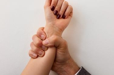 Eine Männerhand umgreif sehr fest eine Frauenhand 