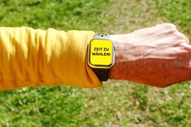 Eine Hand mit einer Smartwatch auf deren Anzeige steht: Zeit zu wählen