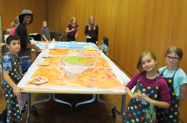 Mehrere Kinder malen gemeinsam ein Bild 