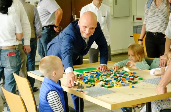 Ein Mann und Kinder spielen Lego