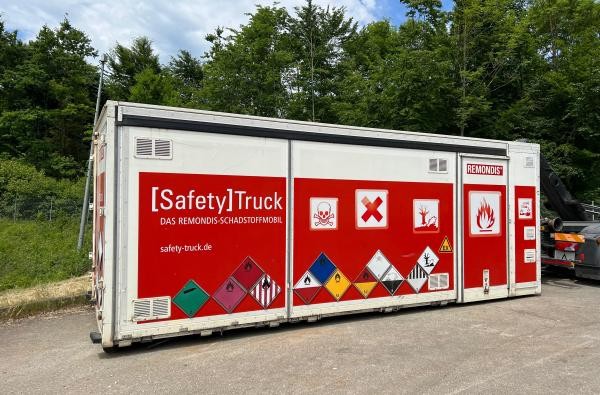 © Abfallwirtschaft/Landratsamt Zollernalbkreis Schadstoffmobil-Container in den Farben rot und weiß vor grünen Bäumen