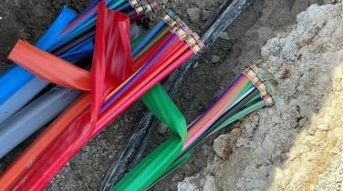 Glasfaserkabel in den verschiedenen Farben liegt in einer Baugrube