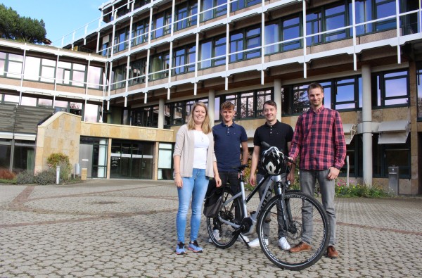 Vier Mitarbeitende des Sachgebiets Planung und Verkehr mit einem Fahrrad vor dem Landratsamt.