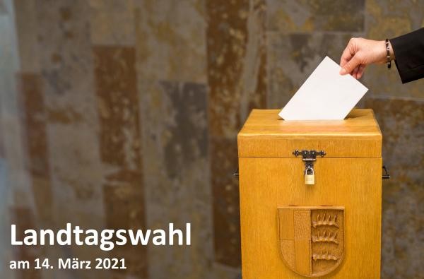 Wahlurne in die ein Wahlbrief eingeworfen wird, nebenstehend der Schriftzug Landtagswahl am 14. März 2021