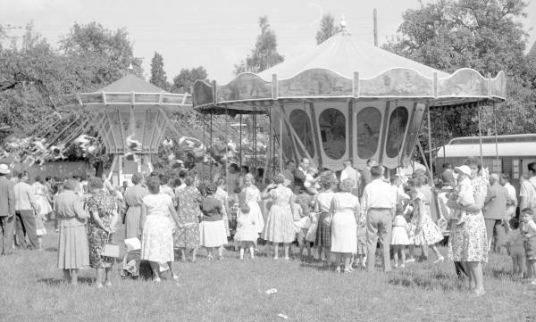 schwarz-weiß Foto, zwei Kettenkarusselle mit Menschenmenge