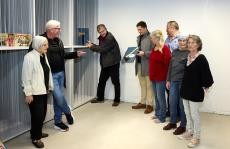 Bild: verschiedene Künstler vor Bildlagerregal mit Kunstwerken