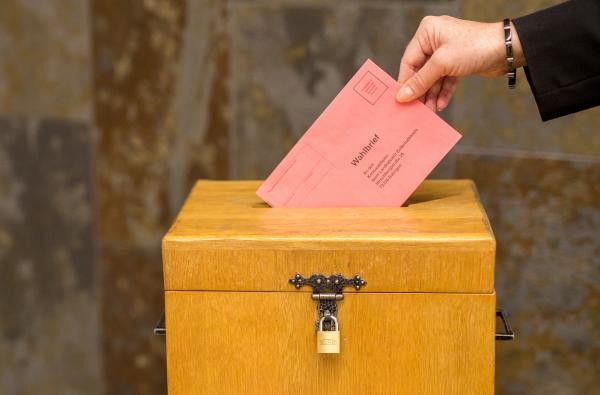 Die Bundestagswahl steht bevor. Für die Einreichung der Wahlvorschläge gelten Fristen. ©Roland Beck Eine Frau wirft einen Umschlag in eine Wahlurne.