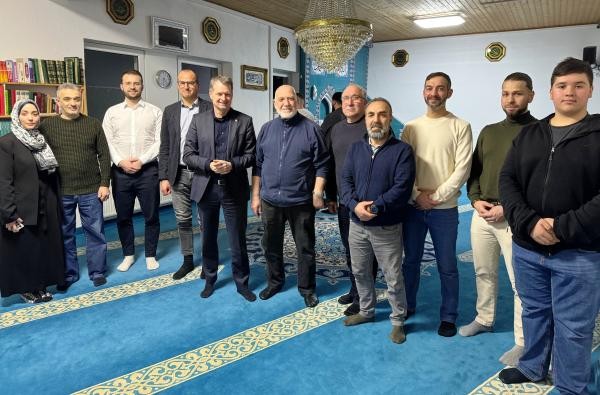 Landrat Günther-Martin Pauli (Fünfter von links), Sozial- und Rechtsdezernent Georg Link (Vierter von links) sowie Sanel Dacic vom Migrationsbeirat (Dritter von links) im Gespräch mit Vertretern und Mitgliedern der Fatih-Moschee Balingen. ©Landratsamt Zollernalbkreis Viele Personen stehen in einem Raum, der Fatih-Moschee in Balingen