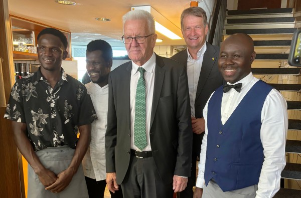 © Landratsamt Zollernalbkreis / Ministerpräsident Winfried Kretschmann besuchte im September 2024 auf Einladung von Landrat Günther-Martin das Refugio in Hechingen. 5 Männer stehen in einem Restaurant nebeneinander
