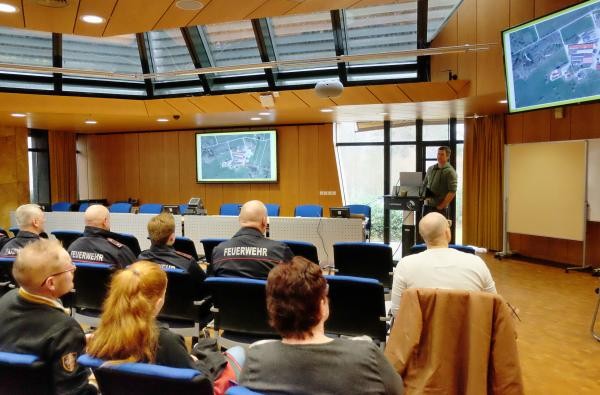 Benjamin Blickle berichtet bei der Fachveranstaltung im Landratsamt Zollernalbkreis vom Brand auf seinem Milchviehbetrieb in Winterlingen. ©Landratsamt Zollernalbkreis Ein großer Raum, in dem Menschen sitzen. Ein Mann spricht zu ihnen.