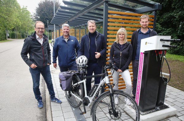 Reichlich Platz für Zweiräder und gut geschützt: Landrat Günther-Martin Pauli (Mitte) macht sich zusammen mit Matthias Bodmer (links) und Heiko Käppel, dem Schulleitungs-Team der Philipp-Matthäus-Hahn-Schule, sowie Catharina Pawlowski, Dezernentin für Verkehr und Kreisimmobilien, und Mobilitätsmanager Sebastian Mayer ein Bild von der neuen Fahrradabstellanlage samt Reparatur- und Lademöglichkeit an der Kreisschule in Balingen. ®Landratsamt Zollernalbkreis Mehrere Personen stehen an einer Radabstellanlage.