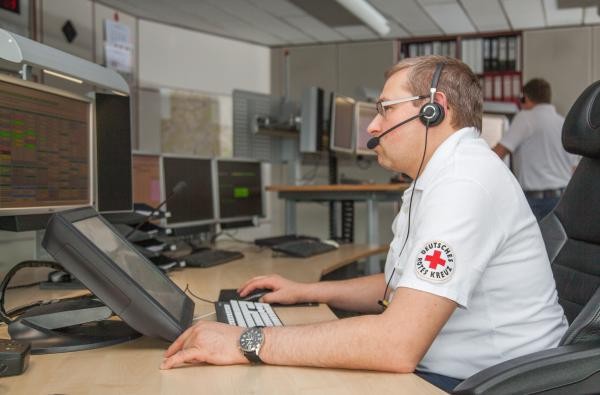Rund um die Uhr da für Menschen in Not: Die Disponentinnen und Disponenten der Leitstelle sorgen dafür, dass Hilfe zielgenau kommt. ©DRK Zollernalb Ein Mann sitzt vor einem Computer und spricht über ein Headset am Telefon.