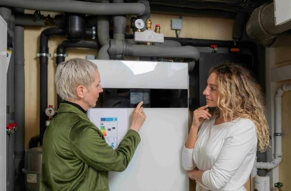 Welches Heizungssystem passt zu mir? Orientierungshilfe gibt die Energieagentur Zollernalb in einem Online-Vortrag. ©Daniel Döbler/Zukunft Altbau Zwei Frauen stehen vor einer Heizanlage