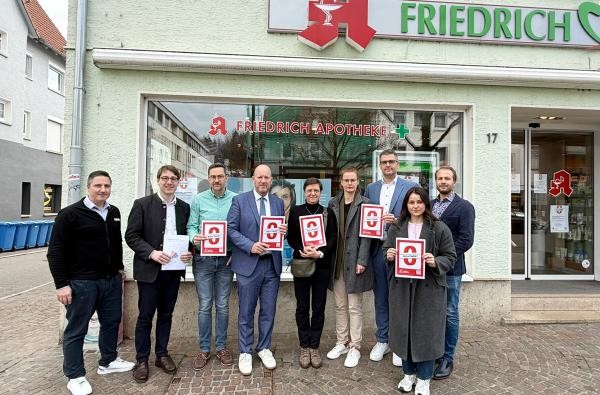 Beim Austauch zwischen Vertretenden der Apothekerschaft, Bürgermeistern und der Landkreisverwaltung wurde deutlich, dass Apotheke für eine verlässliche Gesundheitsversorgung im Zollernalbkreis unverzichtbar sind. ©Landratsamt Zollernalbkreis Mehrere Frauen und Männer stehen vor einer Apotheke.