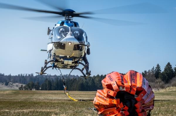 Polizeihubschrauber im Schwebeflug mit Bambi-Bucket © Markus Voelter Photography http://photo.voelter.de Polizeihubschrauber schwebt, im Vordergrund ist ein Löschwasserbehälter zu sehen