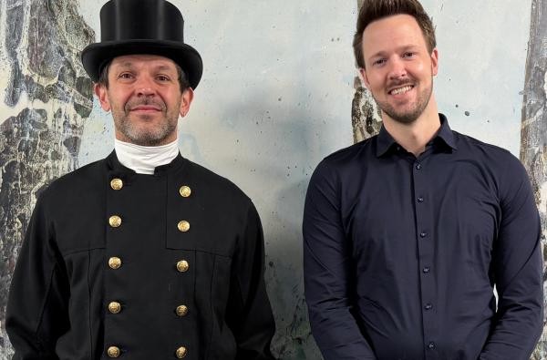 Oliver Banholzer (links) wurde von Enrico Möller erneut zum Bezirksschornsteinfeger im Kehrbezirk Nr. 9 im Zollernalbkreis bestellt. © Landratsamt Zollernalbkreis Ein Schornsteinfeger in traditioneller Kleidung und ein Mann mit blauem Hemd