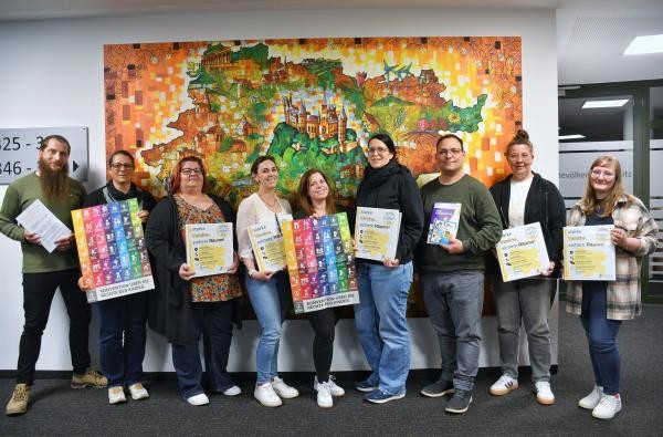 Start für das Projekt "Starke Vereine - sichere Räume": Vertreter des Kreisfeuerwehrverbands, des TV Weilstetten und der Michelezunft Hartheim mit Jugendreferent Dominik Speißer (links) und Jugendreferentin Lena Mispelhorn (rechts). ©Landratsamt Zollernalbkreis Mehrere Personen stehen vor einem bunten Bild.