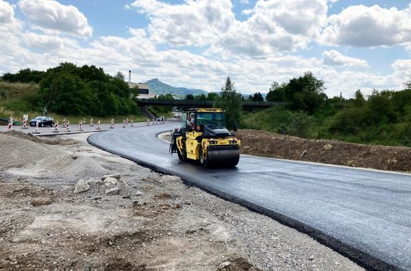 Die provisorische Umfahrung im Zusammenhang mit dem Neubau des Kreisverkehrs Lotzenäcker II ist soweit fertiggestellt - ab Montag, 27. Juli, rollt darauf der Verkehr. ©Landratsamt Zollernalbkreis Eine Baustelle. Eine Walze macht den neuen Straßenbelag eben.