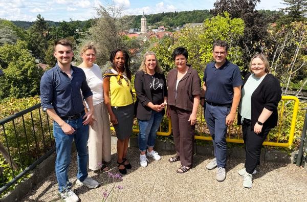 Sie stellen die Interkulturelle Woche im Zollernalbkreis gemeinsam auf die Beine (von links): Julian Stauß (Caritas Schwarwald-Alb-Donau), Silke Ott-Zetzsche (Stadt Albstadt), Estelle Koschnike-Nguewo (Landratsamt Zollernalbkreis), Nadine Gotthold (Stadt Burladingen), Mechthild Uhl-Künzig (Caritas f. d. Dekanat Zollern), Micha Haasis (Diakonie Balingen), Daniela Eichinger (Stadt Hechingen). Nicht auf dem Bild: Jasmin De Barros (Stadt Balingen). ©Landratsamt Zollernalbkreis Fünf Frauen und zwei Männer - die Steuerungsgruppe der Interkulturellen Woche im Zollernalbkreis - stehen auf einer Terrasse nebeneinander.