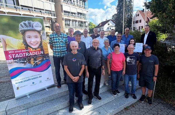 Siegerehrung im Landratsamtamt: Landrat Günther-Martin Pauli (rechts) würdigte die Rekord-Leistungen beim STADTRADELN. ©Landratsamt Zollernalbkreis Mehrere Frauen und Männer stehen auf einer Treppe und freuen sich.