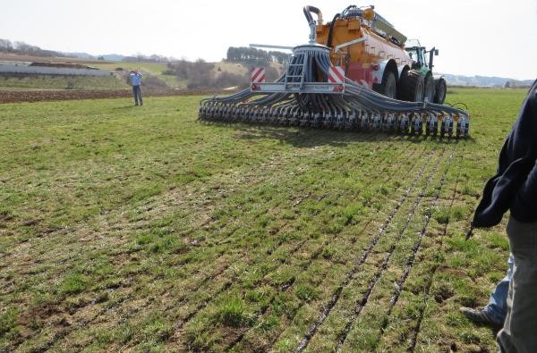 Ein Fahrzeug bringt Gülle auf einem Feld aus.