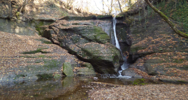 Wasserfall zwischen Gestein und Bäumen