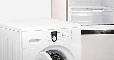 Eine Waschmaschine, ein geöffneter Kühlschrank 