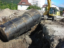 Ein Öltank wird von einem Bagger aus einer Baugrube herausgehoben